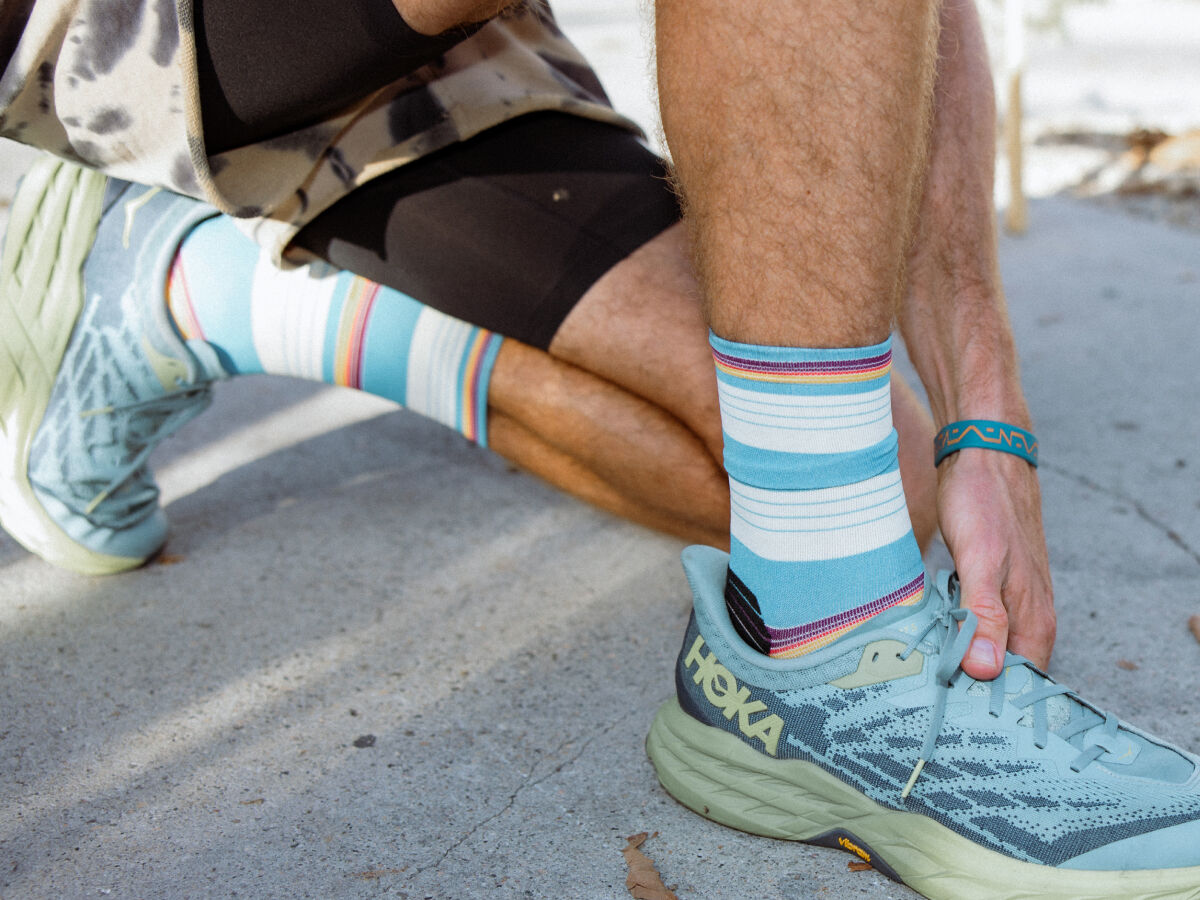 Close up image of person wearing running shoes and blue crew socks